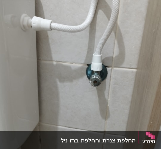צינור מים מחובר לשירותים על קיר אריחים